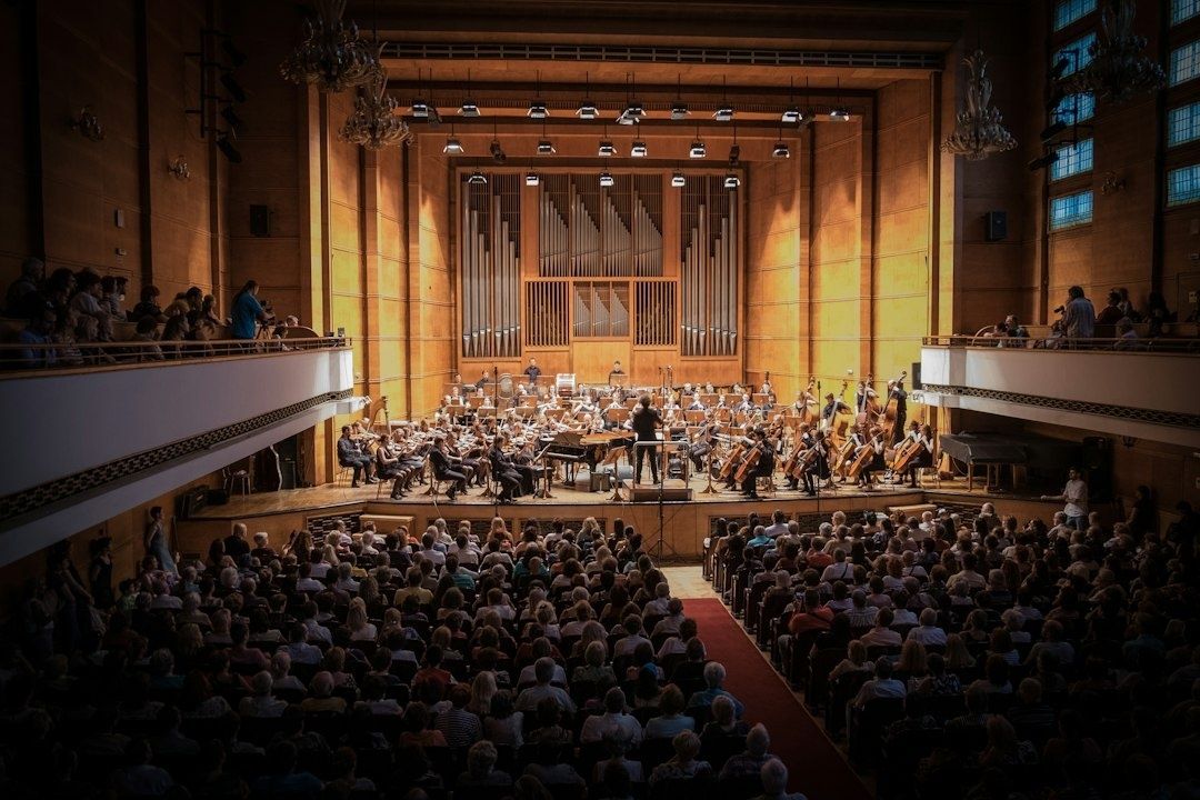 Volle concertzaal met orkest en dirigent tijdens een uitvoering