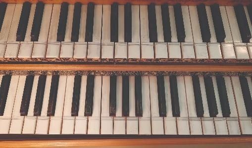 Close-up van twee rijen zwart-witte klaviertoetsen van een historisch instrument